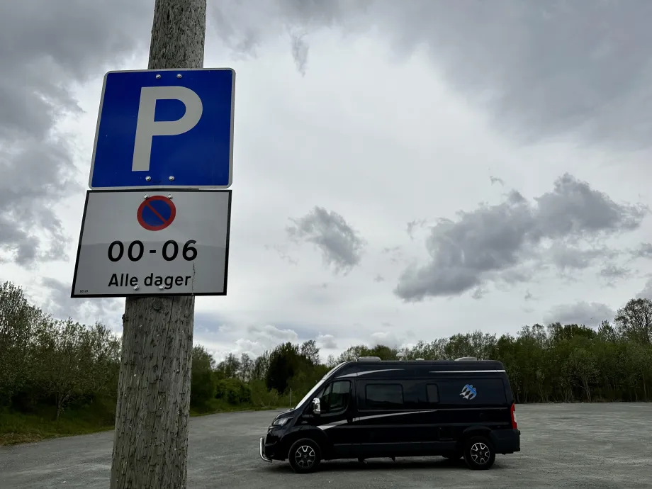 Bildet viser en bil som står parkert på en innfartsparkering.