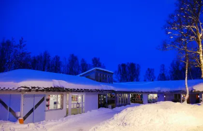 Norrøna barnehage sett utenfra en snørik vinterdag i blåtimen