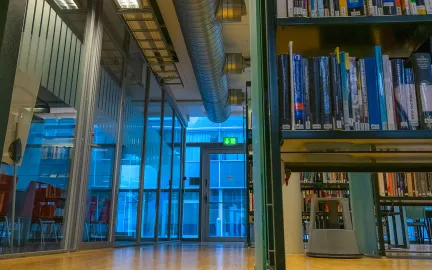 Shared reading på hovedbiblioteket En bokhylle sett nedenfra og opp står til høyre. Foto.