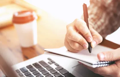 Nå kan du bestille grupperom selv Nærbilde av en hånd som holder en penn mot en notatbok. Foto