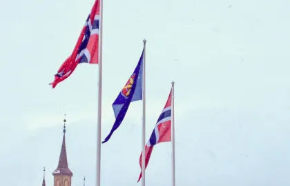 Kvensk flagg sammen med to norske flagg To norske og et kvensk flagg vaier utenfor Tromsø rådhus i mars 2019