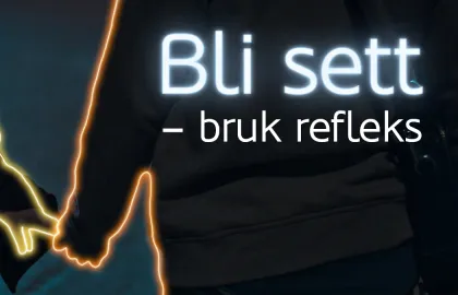 Refleks trafikk To personer som holder hender går langs mørk vei. Tekst i bildet sier: Bli sett - bruk refleks.